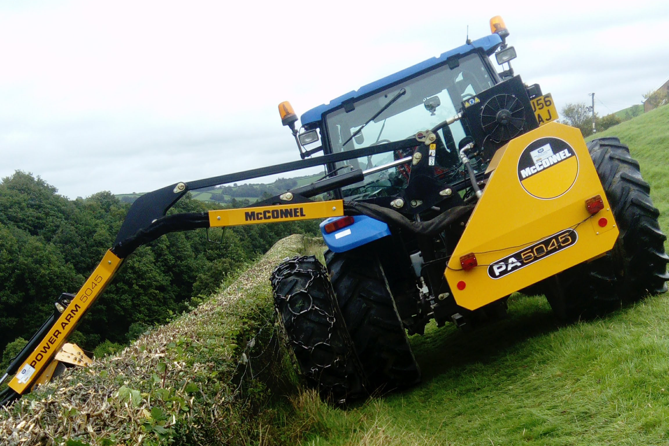 New Holland TL100A with McConnel hedgecutter, fitted with Stocks Ag Dual Wheels on steep terrain